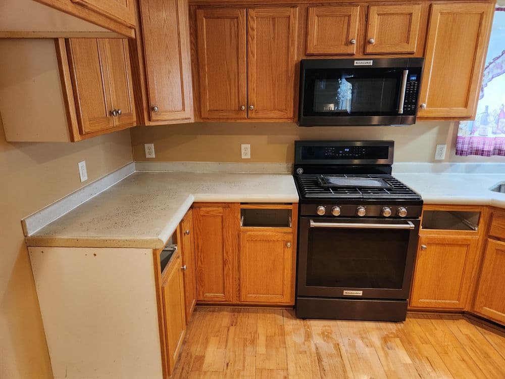 Modern kitchen with oak cabinets, stainless steel appliances, and a polished countertop.