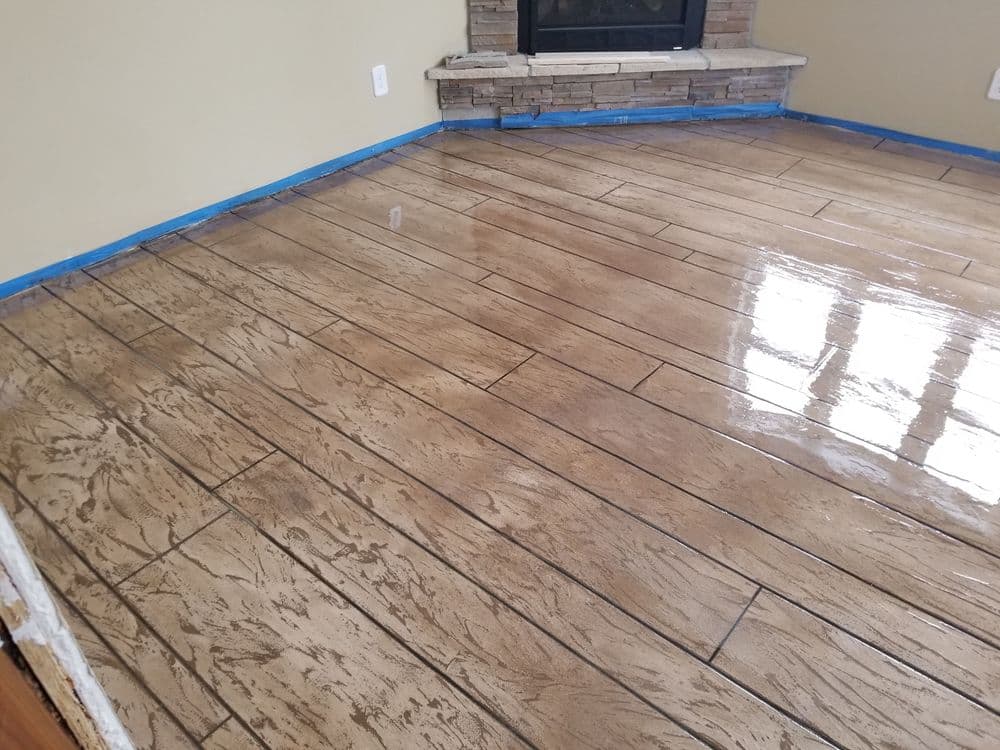 Shiny stained concrete floor with a fireplace and freshly applied sealant.